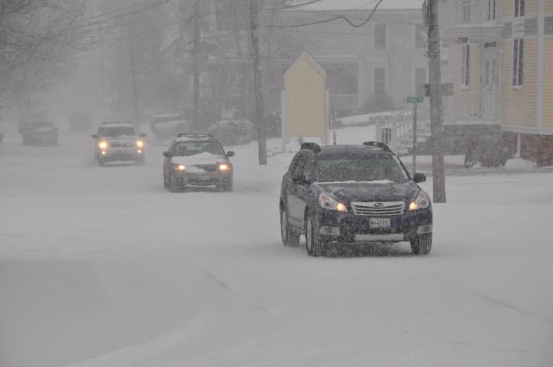 Cars proceed slowly through downtown Boothbay Harbor February 8. BEN BULKELEY/Boothbay Register. Below: A snowplow turns on to Oak Street in Boothbay Harbor near The First bank as snow starts to pile up. GARY DOW/Boothbay Register Cars proceed slowly through downtown Boothbay Harbor February 8. BEN BULKELEY/Boothbay Register