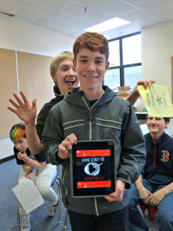 Freshman Noah Sherburne with his graphic design against smoking. Photobombing runs rampant at meetings. KATRINA CLARK/Boothbay Register
