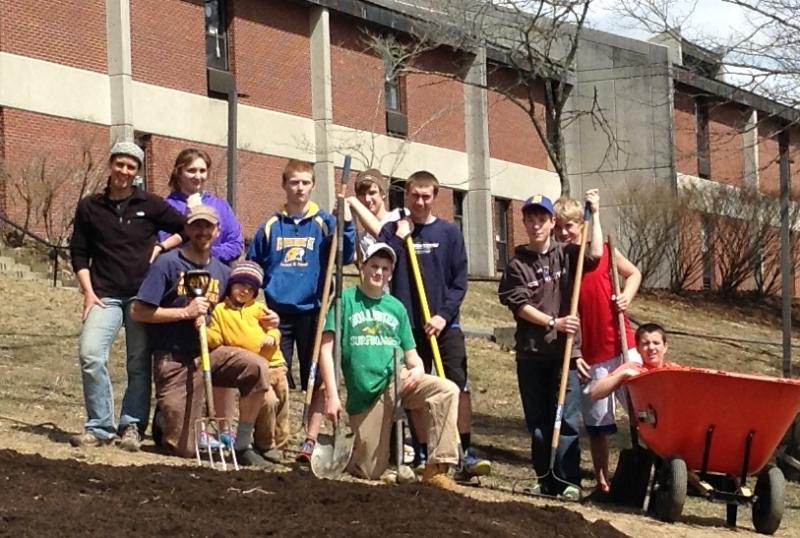 Volunteers working in the forest garden. From left, top row: Jessica Ganong, Allie Simmons, Xavier Downing, Zach Genrich, Nick Kilgus, Noah Sherburne, Draco Peaslee. Bottom row, from left: Bryan Dionne, Takoda Dionne, Riley Spear and (in the wheelbarrow) Nick Labonte. Courtesy of Bryan Dionne