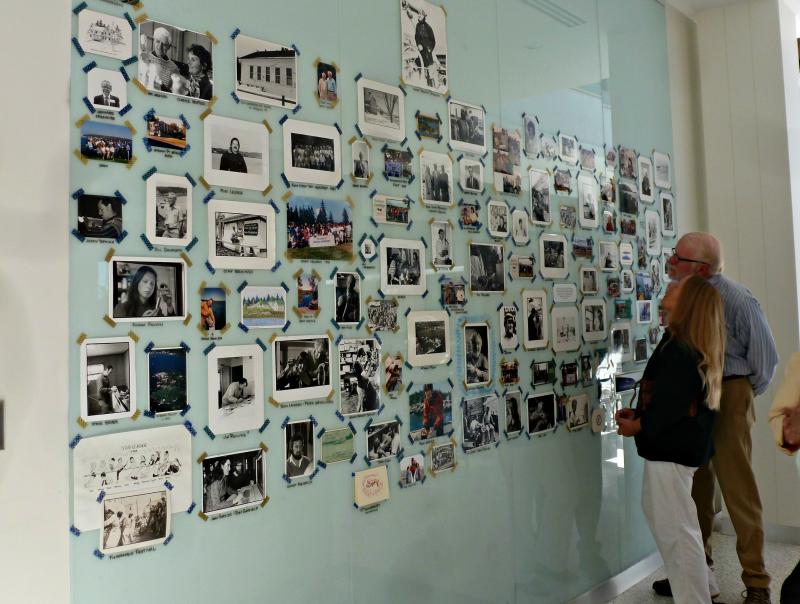 The plexiglass wall in Bigelow Labs front hallways is filled with photos from Bigelow's 40-year history, including many staff Christmas cards. KATRINA CLARK/Boothbay Register