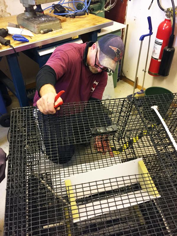 Tim Simmons makes adjustments to a shrimp trap made in China for Swedish fishermen. Courtesy of Tim Simmons