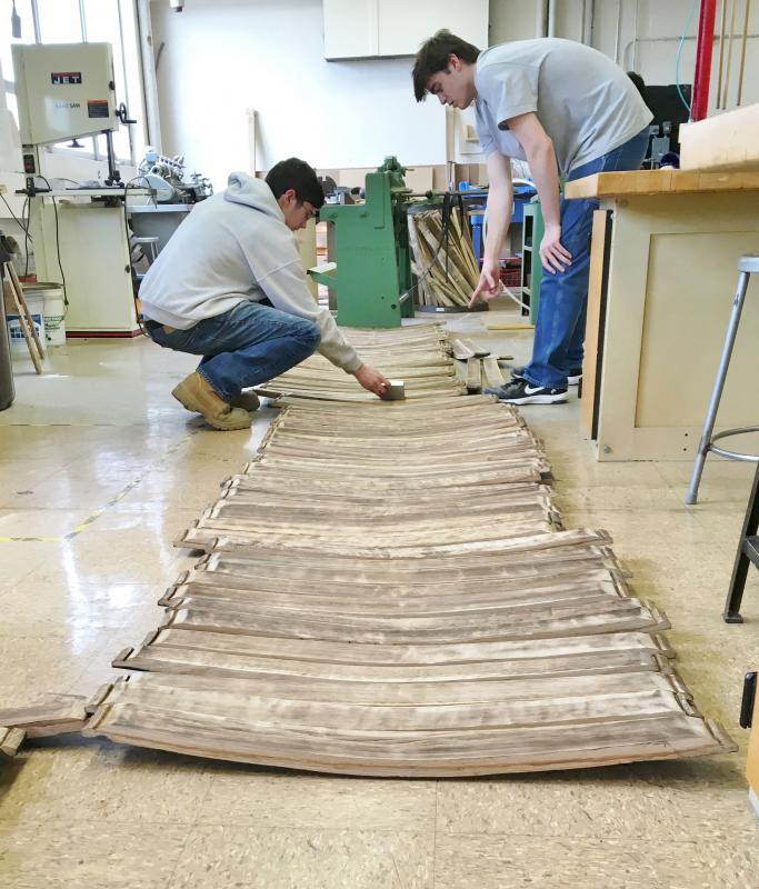 Dylan Peters, left, and Riley Johnson work on preparing the barrel staves for construction of the chairs. Courtesy of Kris Folsom/CMBG