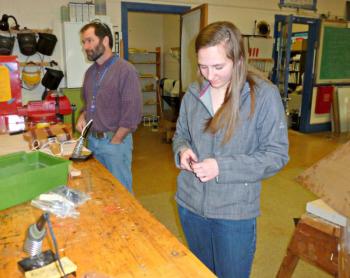 Sophomore Angela Machon adjusts the wires she’s working on while teacher Chip Schwehm asks students about how to fix a problem with another guitar. KATRINA CLARK/Boothbay Register