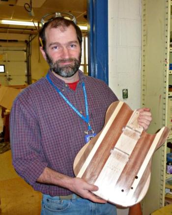 Teacher Chip Schwehm holding a guitar body created Junior Kyler Carty. KATRINA CLARK/Boothbay Register