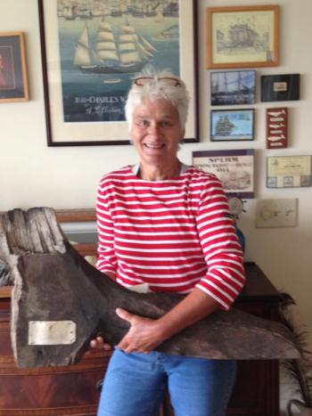 Sally Bullard holds a piece of the 'Charles W. Morgan,' originally removed during the first major restoration work performed between 1967 and 1970. The hanging knee timber is hand hewn oak. Hanging knees were vertical pieces cut from the natural section of oak where a limb grew out of the trunk and were fastened with large drift pins of iron or brass. LISA KRISTOFF/Boothbay Register