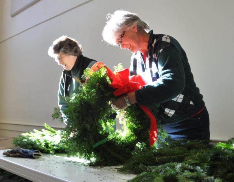 Valerie Betts works at the wreath table November 14 during a Boothbay Region Garden Club event at the Southport Town Hall. Below: Jane Lunt, left, and Penny Thumith work together to construct cocoa cones, and De Amplo constructs a gingerbread house. BEN BULKELEY/Boothbay Register Valerie Betts works at the wreath table November 14 during a Boothbay Region Garden Club event at the Southport Town Hall. BEN BULKELEY/Boothbay Register