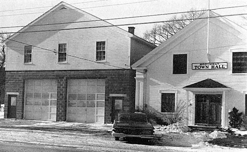 This Boothbay Center shot, from the 1961-1962 Boothbay town report, shows the new cement block garage with town office upstairs, as well as the 1848 town hall. George McEvoy preserved the town hall from being demolished, moving it to the Railway Village in 1990 where it was put in good repair. After the garage/office stood empty and unsold for some time, McEvoy also bought and repaired it, greatly improving its looks. This Boothbay Center shot, from the 1961-1962 Boothbay town report, shows the new cement block garage with town office upstairs, as well as the 1848 town hall. George McEvoy preserved the town hall from being demolished, moving it to the Railway Village in 1990 where it was put in good repair. After the garage/office stood empty and unsold for some time, McEvoy also bought and repaired it, greatly improving its looks.