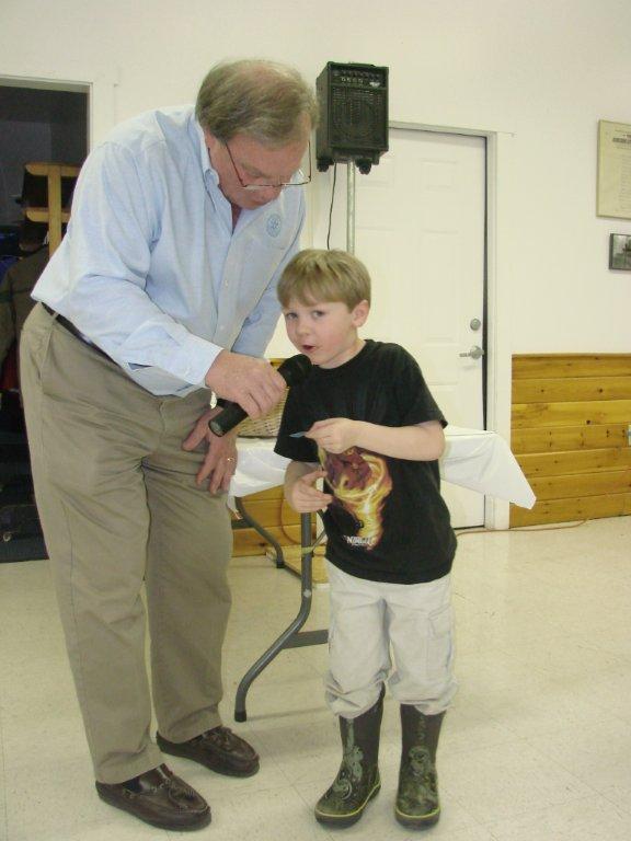 Five-year-old Mason Paquette helps Bill Bailey announce some of the raffle ticket numbers drawn at the Bowl Supper. LISA KRISTOFF/Boothbay Register Five-year-old Mason Paquette helps Bill Bailey announce some of the raffle ticket numbers drawn at the Bowl Supper. LISA KRISTOFF/Boothbay Register