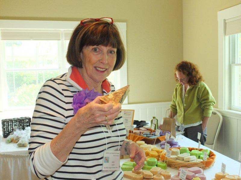 Outgoing president Irene Gerny samples goat milk soap bars at the Vendor's Market during the Garden Club Federation of Maine's 2013 convention at Spruce Point Inn on June 18-20. LISA KRISTOFF/Boothbay Register Outgoing president Irene Gerny samples goat milk soap bars at the Vendor's Market during the Garden Club Federation of Maine's 2013 convention at Spruce Point Inn on June 18-20. LISA KRISTOFF/Boothbay Register
