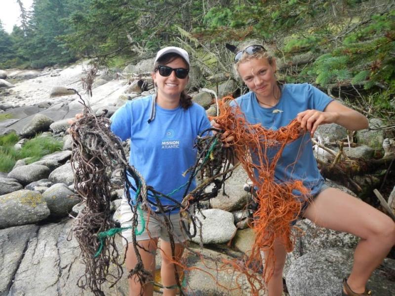 Michelle Levano and Marina Garland pick up trash on the shores of Hurricane Island before returning to Boothbay on June 24. Courtesy of the Rozalia Project