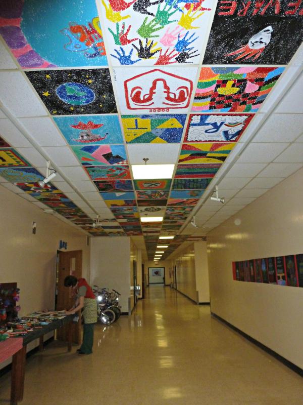 The hallway outside the art room shows tiles going down to the very end. Jessica Nadeau rearranges art displays in the hallway. KATRINA CLARK/Boothbay Register