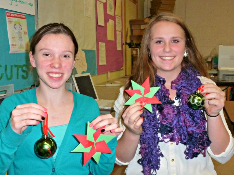 Eighth grade LOAFS Maddie McLellan, left, and Jackie McLoon, hold up snowflakes and balls decorated for the upcoming holiday dance. KATRINA CLARK/Boothbay Register