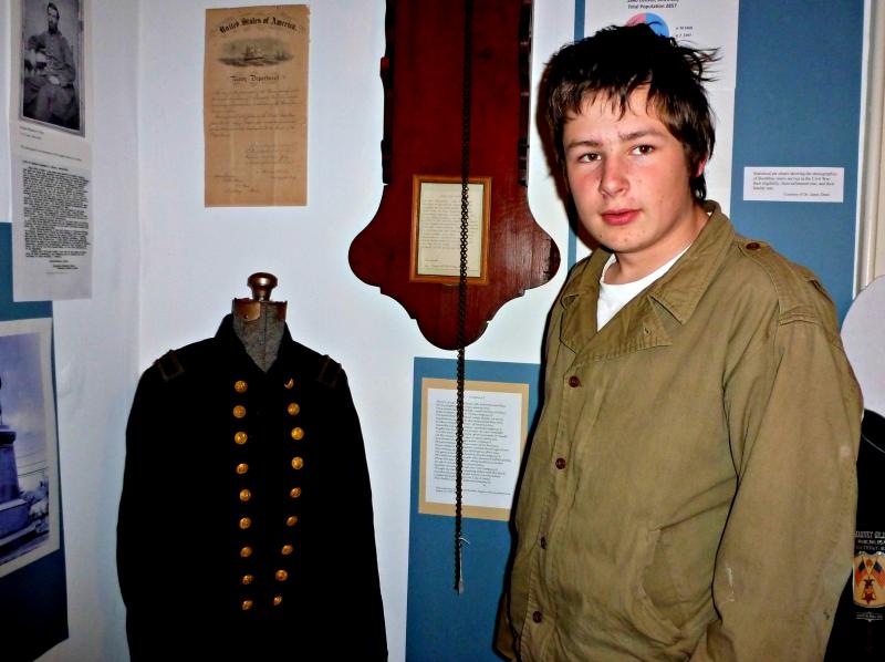 Devyn Campbell shows visitors one of the Civil War coats on display. KATRINA CLARK/Boothbay Register