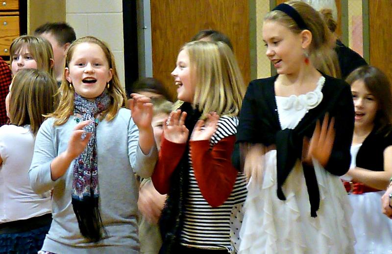 Three fourth-grade girls cut loose during the singalong of “We Wish You a Merry Christmas.” KATRINA CLARK/Boothbay Register