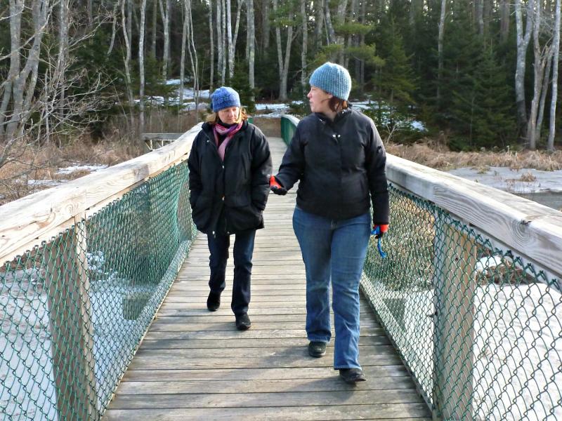Hall, right, and Stockwell, left, cross the Penny Lake bridge. The river beneath them is completely frozen over. KATRINA CLARK/Boothbay Register