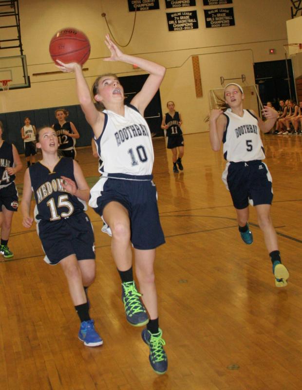 Maggie Larson goes high to the hoop for two of her team-leading 12 points in the seventh grade girls’ win over Medomak. KEVIN BURNHAM/Boothbay Register Larson