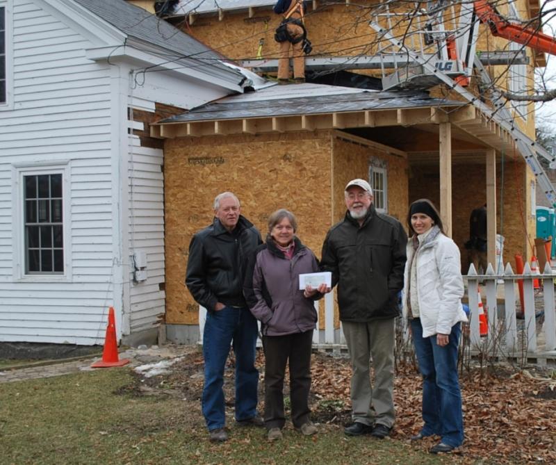 Friends of the Library volunteers, from left, treasurer Duane Dunbar and president Ann Kelley, present a check for $30,000 to Boothbay Harbor Memorial Library executive director Tim McFadden and Nicole Poulton, president of the Boothbay Harbor Memorial Library board of trustees, as construction on the addition to the library continues. Courtesy of Ann Kelley Library