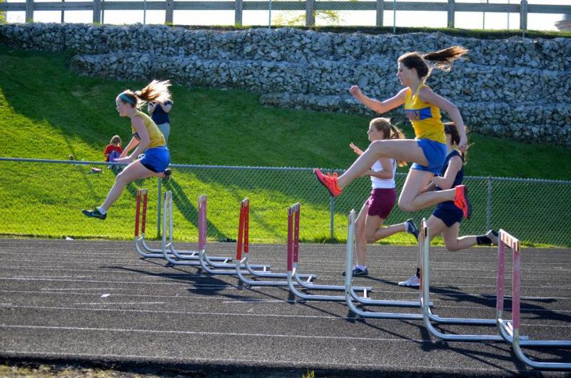 Sinead Miller and Angie Perkins clear the hurdles in the 300m event. Perkins placed third and Miller fifth. Courtesy of Karl Alamo Photo of Sinead Miller and Angie Perkins