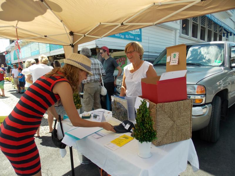 A silent auction bidder examines the Sea Dog baseball hat. KATRINA CLARK/Boothbay Register