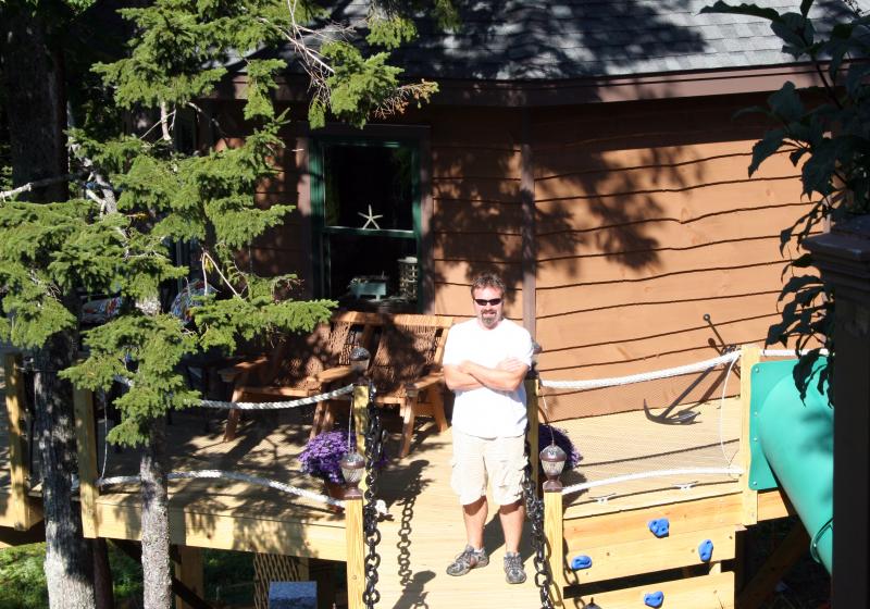 RONNIE CAMPBELL stands on the deck of another treehouse he just completed for a couple in Boothbay Harbor. SUZI THAYER/Boothbay Register