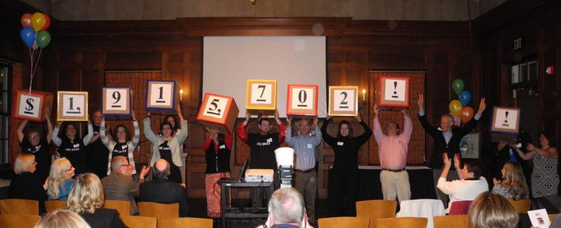 UNITED WAY CAMPAIGN CABINET members and Loaned Executives hold up signs revealing the total amount raised ($1,915,702) to the Campaign Finale audience. Courtesy of United Way