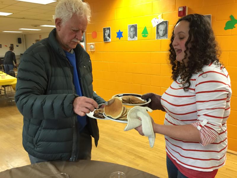 Bruce MacDonald helps himself to some pancakes offered by Rose Mooney. SUZI THAYER/Boothbay Register