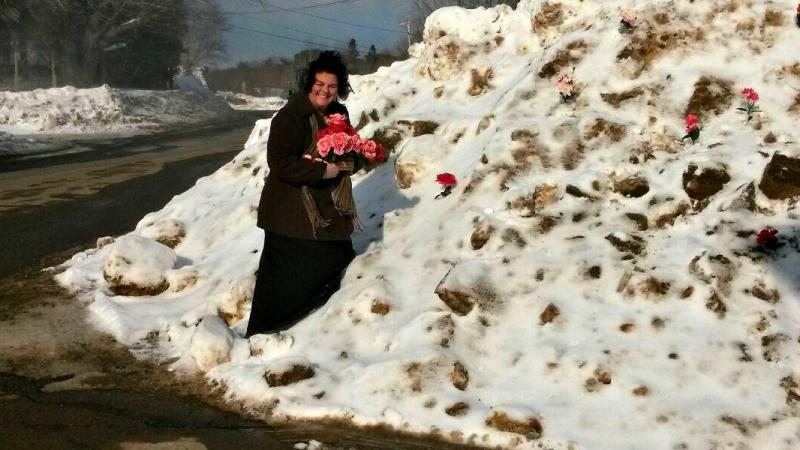 Tammy Serrano sticks plastic flowers in the giant snowbank to brighten the day of customers. Courtesy of Shelley Smith.