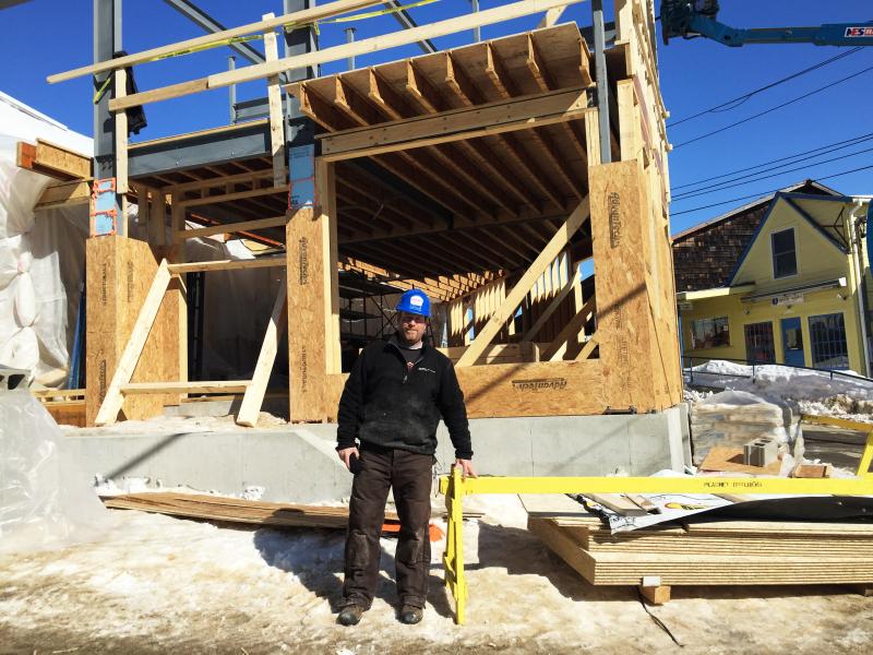 Garron Heath, a supervisor for Peachey Builders, stands outside the structure being built at 8 Wharf Street on March 6. SUZI THAYER/Boothbay Register
