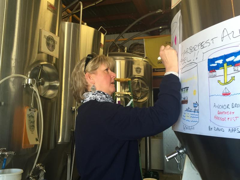 Barb McDonald draws her idea for the can contest, which will appear on labels for this year's Harbor Fest Ale. Her idea was a “Spakle Ale.” KATRINA CLARK/Boothbay Register