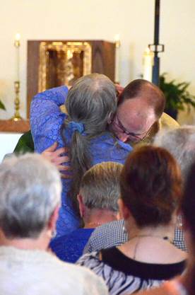 Father Steven Cartwright gives his mother, Lynn, a hug at his first Mass. Courtesy of Lois Czerniak, Roman Catholic Diocese of Portland