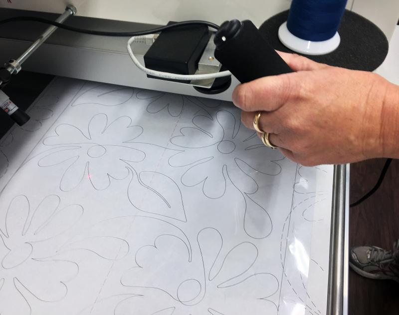 Deb Boucher uses the back side of her longarm quilting machine to stitch a pattern from a template. SUZI THAYER/Boothbay Register