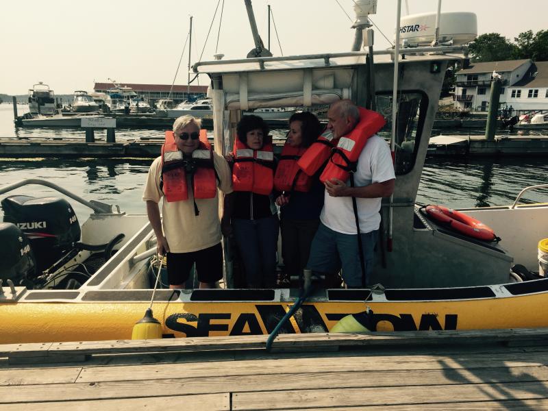 These passengers who were on the Lazy Jack when it got hit by a lobster boat on Wednesday afternoon are brought to the town dock aboard the Sea Tow boat. Courtesy of Bruce White