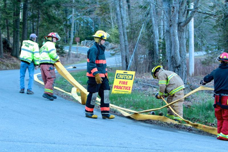 Area firefighters work together to connect hoses during the drill on Southport Island April 19. Courtesy of Robert Mitchell