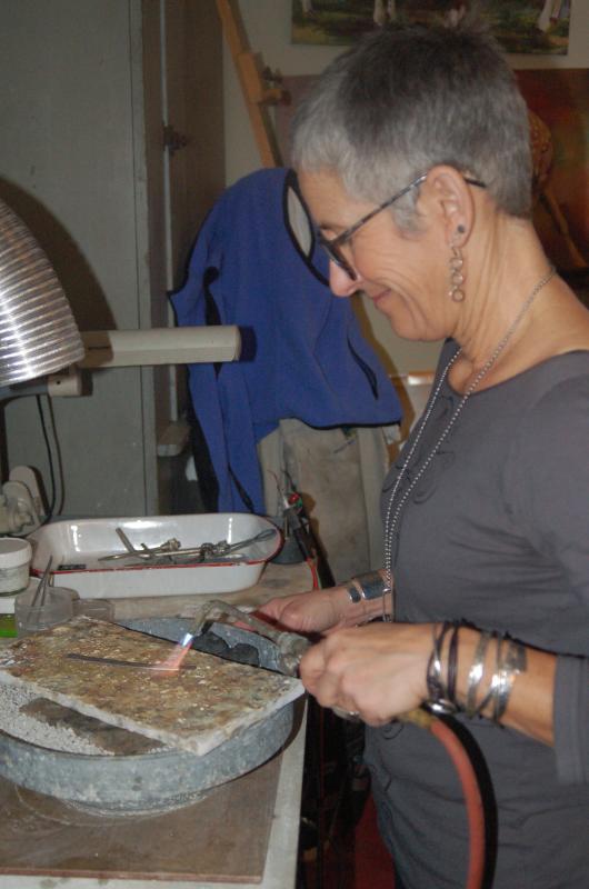 Anita Roelz heats a silver band used to fashion a bracelet. ART MAYERS/Boothbay Register