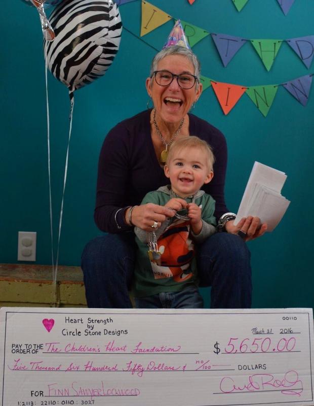 Anita Roelz and grandson Finn hold check showing donations to the Children’s Heart Foundation. Courtesy Anita Roelz