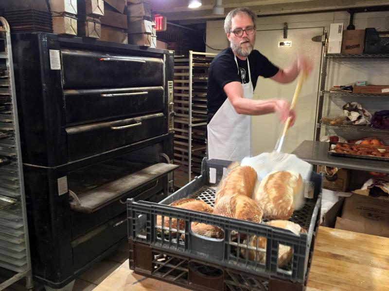 Derek DeGeer of Hootenanny Bread removes some of the nearly 200 loaves he sometimes bakes in a day at his Damariscotta location, beneath the Damariscotta River Grill. SUZI THAYER/Boothbay Register