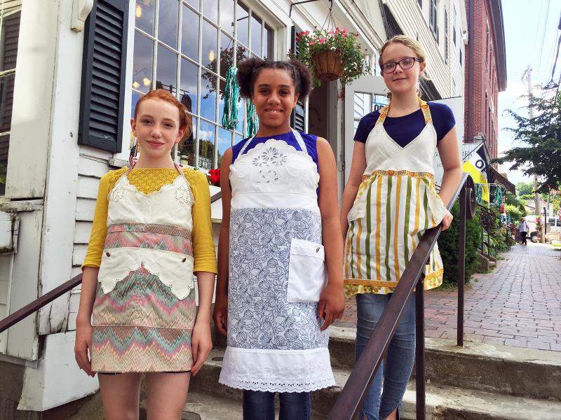 Madison Browne, left, Nylaina Wilson and Brooke Lindsay model some of the PaperDoll Aprons during the Wiscasset Art Walk on June 30. SUZI THAYER/Boothbay Register
