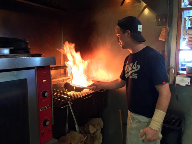 Grill chef Kelsy Markee cooks seafood and steaks with a wood fired grill. SUZI THAYER/Boothbay Register
