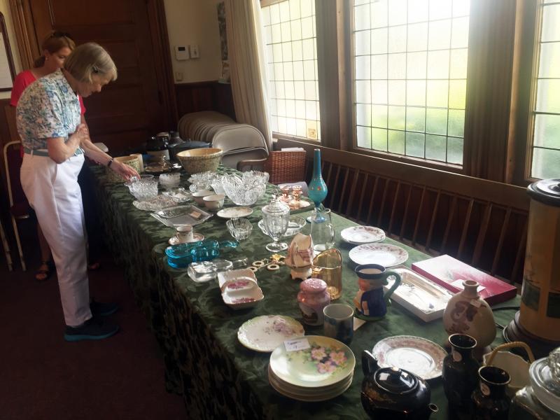 Liz Furber inspects some of the treasures at the Southport United Methodist Church during the Southport Country Fair and Lobster Roll Luncheon on July 20. SUZI THAYER/Boothbay Register
