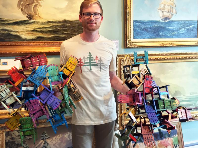 Ryan Hinton holds two pieces of three-dimensional wood art by contemporary reclaimed wood artist Paul Jacobsen. SUZI THAYER/Boothbay Register