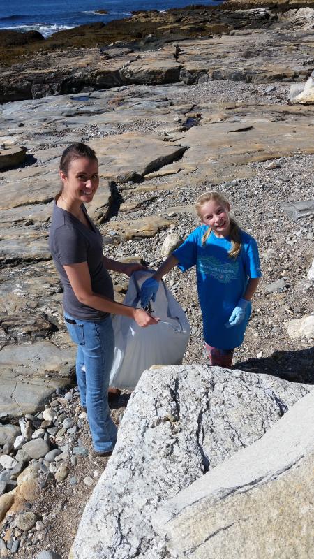 Rachel St. Vincent, left, and Hannah Hills clean up a beach. Courtesy of Elaine Jones
