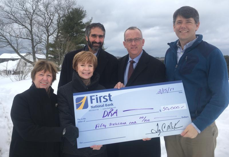 First National Bank presents Damariscotta River Association with a check at DRA Round Top Farm in support of DRA’s capital campaign to enhance education programs, conserve special lands, and protect water quality. Pictured from the left are Emily MacKenzie, DRA leadership gifts chair and former board president; Susan Norton, First National Bank executive vice president and chief administrative officer; Gary Stone, First Advisors vice president and portfolio manager, Tony McKim, First National Bank president and CEO, and Steven Hufnagel, DRA executive director. Courtesy photo