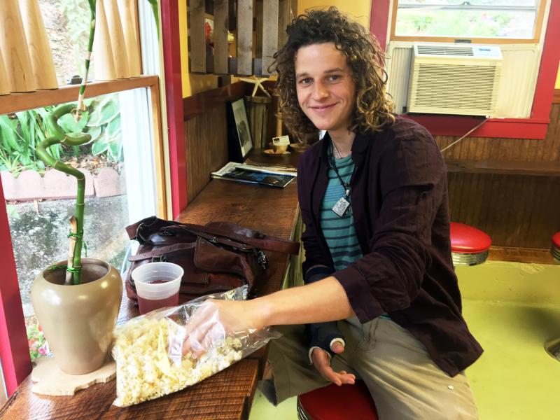 Christian Ingham enjoys some white cheddar popcorn – his own recipe – at Cameron Clan Kettle Corn in Wiscasset. SUZI THAYER/Boothbay Register