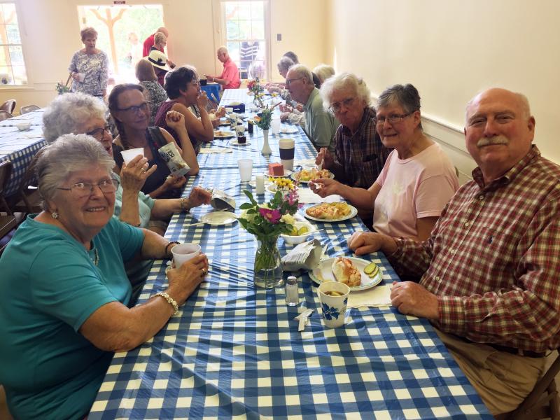 Diners enjoy the lobster rolls, chicken salad rolls, hot dogs and cake. SUZI THAYER/Boothbay Register