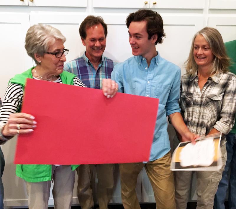 Chairman of the Lincoln Arts Festival Nominating Committee Nancy Nash presents Sam Betts with a large, red, handwritten mock check, made out to Bowdoin College, for $1,000. With Betts are his father, Brad, and mother Danielle. SUZI THAYER/Boothbay Register