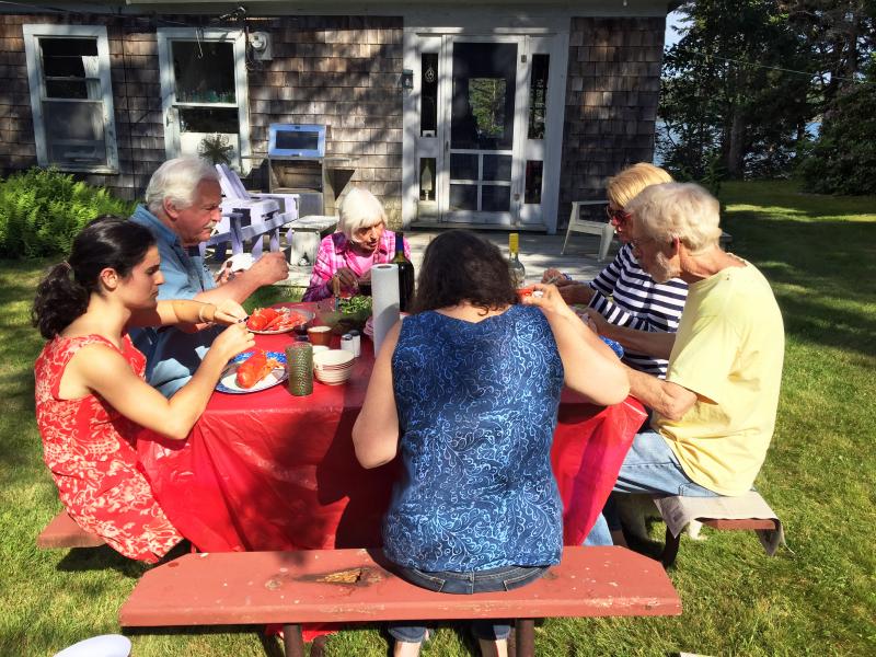 The Thayer clan and cousin Rich have a lobster feed at the cottage on the Fourth of July. SUZI THAYER/Boothbay Register