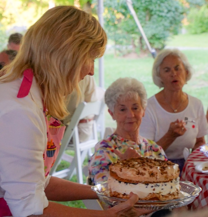 Terri Wells of Wiscasset displays Connie’s Favorite Birthday Cake to guests at Lincoln County Historical Association’s Kermess at Pownalborough Court House. Linda Belmont considers making a bid. Courtesy of Sarah Sutter