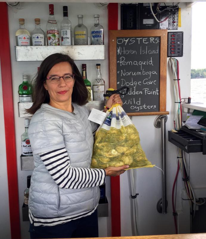 Olga Oros holds a freshly delivered bag of Norumbega Oysters. SUZI THAYER/Boothbay Register