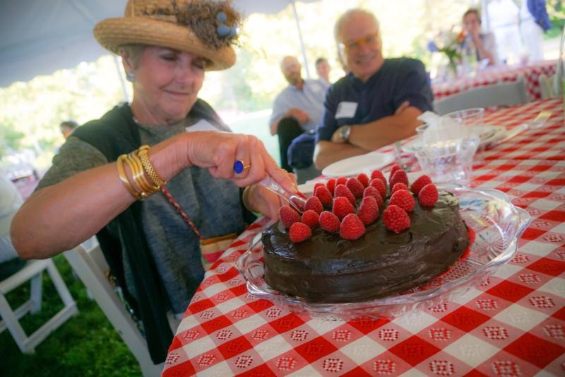Luana Frois of Westport Island slices into a chocolate whiskey cake for which she and her husband were high bidders at Lincoln County Historical Association’s Kermess at Pownalborough Court House. Courtesy of Sarah Sutter