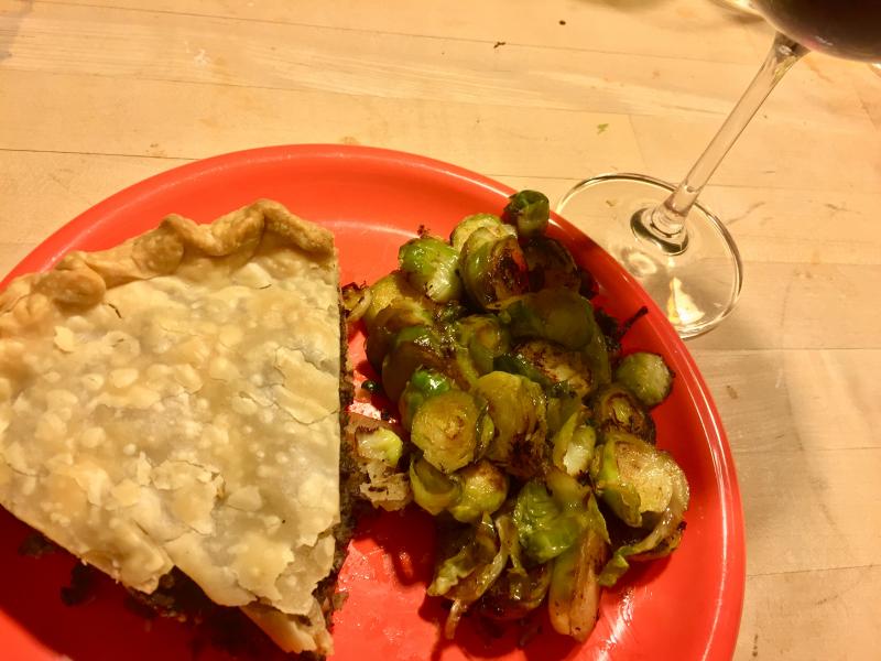 A piece of tourtière with some braised Brussels sprouts and a glass of wine. O.M.G. SUZI THAYER/Boothbay Register
